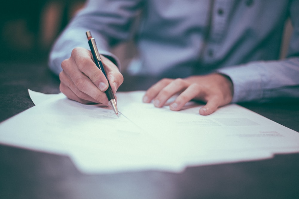 Person reviewing documents and making careful notes